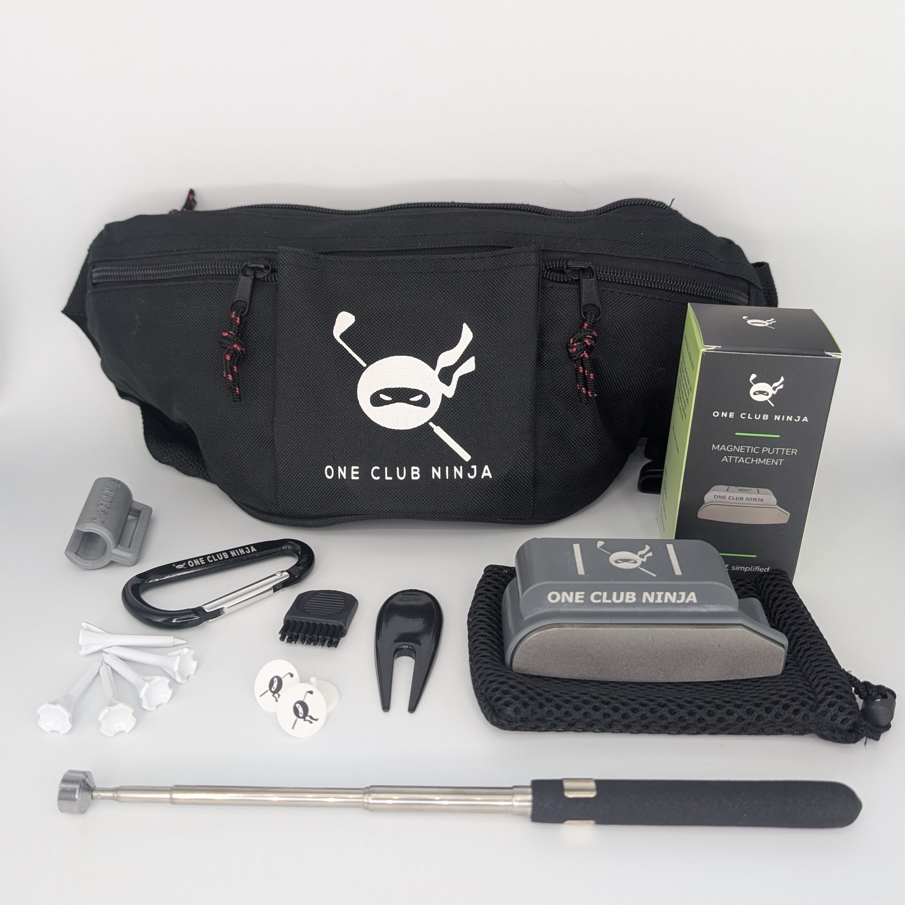 The One Club Kit flat lay with the Obsidian putter attachment, waist bag, telescoping alignment stick, and accessories